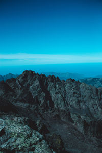 Scenic view of mountains against clear blue sky