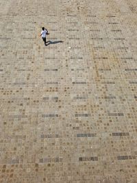 High angle view of boy playing with ball on street