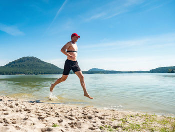 Runner run in water at beach, drops refreshing his body. runner with heart rate monitor  smart watch