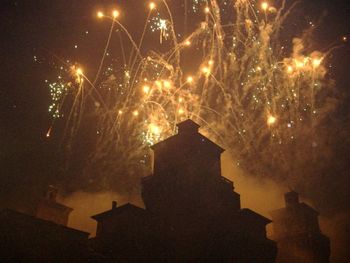 Low angle view of fireworks against sky at night