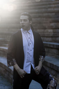 Young male model standing on steps during sunset