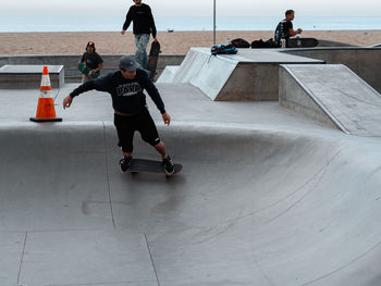 Rear view of man skateboarding on skateboard