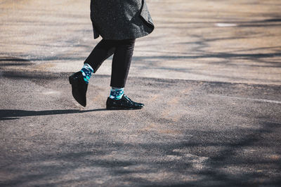 Low section of woman walking on street