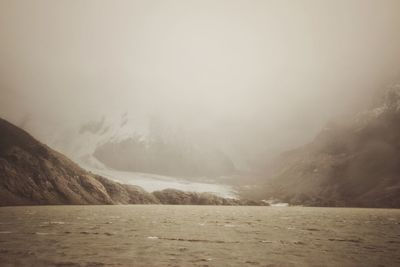 Scenic view of lake, glacier and mountains against sky