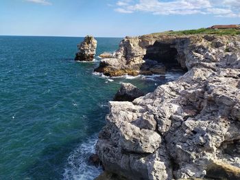 Rock formations in sea against sky