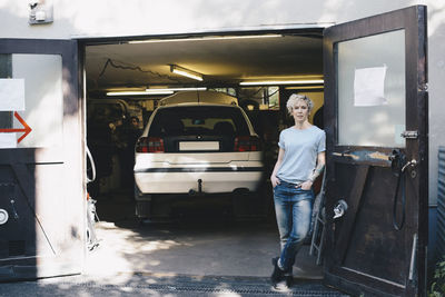 Portrait of woman standing by car