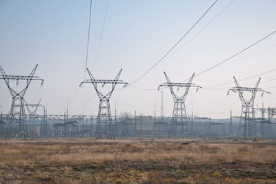 Electricity pylon on field against sky