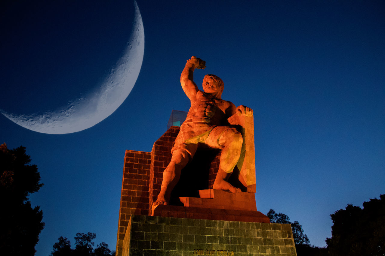 sky, low angle view, sculpture, art and craft, statue, human representation, representation, nature, blue, male likeness, creativity, clear sky, moon, no people, tree, architecture, craft, religion, spirituality, plant