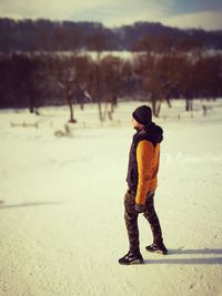 Full length of man standing on snow covered landscape