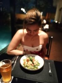 Midsection of woman sitting on table at restaurant