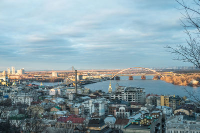 High angle view of city buildings against cloudy sky