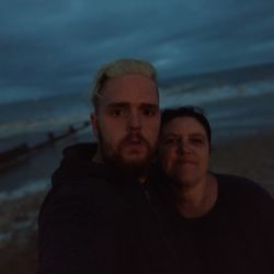 Portrait of man with arms raised at beach