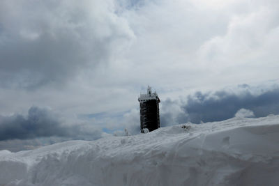 House on snow covered mountain against sky