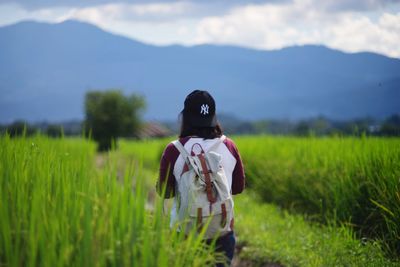 Rear view of woman standing in field