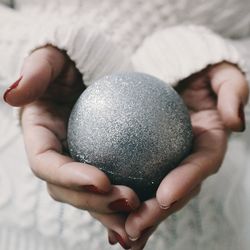 Midsection of woman holding bauble