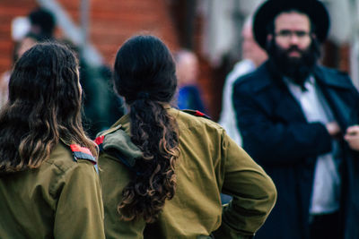 Rear view of people standing in city