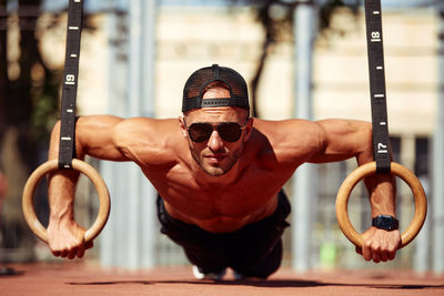 Low angle view of young man with arms raised standing in gym