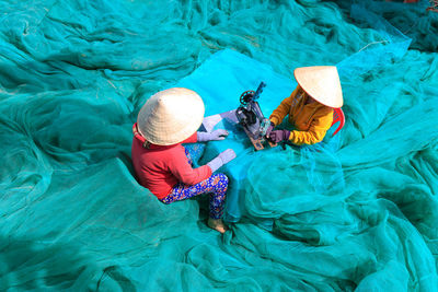 High angle view of women sewing net