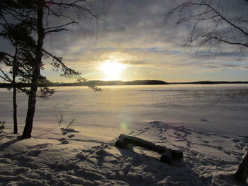 Scenic view of snow covered land during sunset