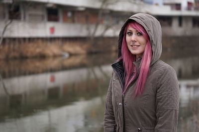 Portrait of woman standing against building