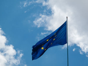 Low angle view of european union flag against cloudy sky
