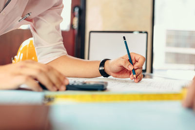 Midsection of man working on table