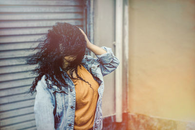 Midsection of woman standing against wall