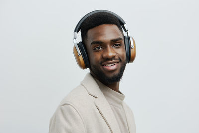 Portrait of young man standing against white background