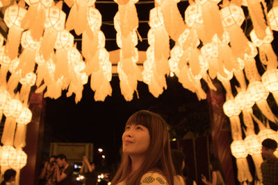 Woman looking at illuminated decoration at night