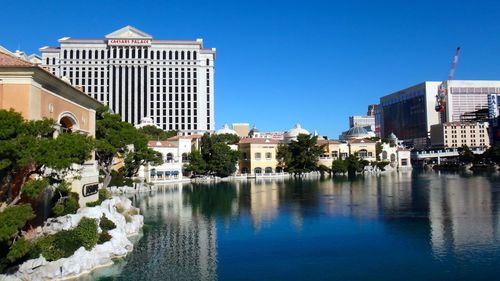 Buildings in city against clear blue sky