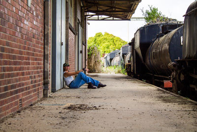 Woman sitting on wall at train station 