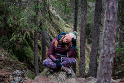 Woman sitting on a rock with her head in her hands whilst solo hiking