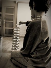 Side view of boy playing block removal game at home