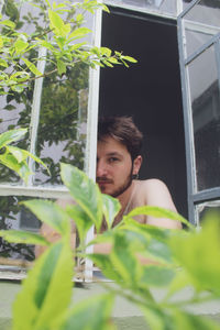 Portrait of young man looking at plants