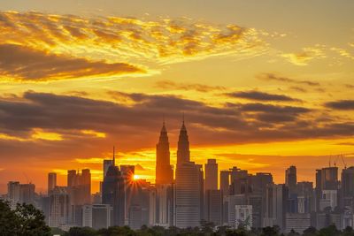 View of buildings against cloudy sky during sunset