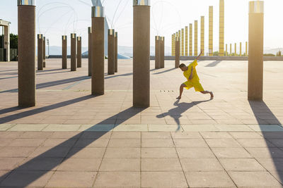 Shadow of woman walking on footpath in city