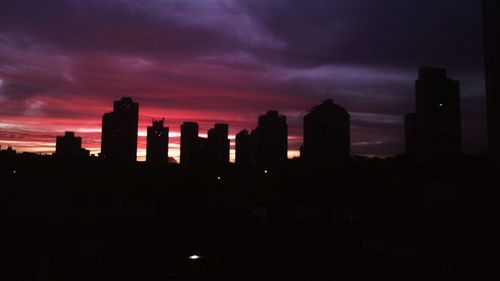 Silhouette cityscape against sky during sunset