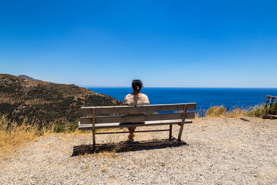 Rear view of man sitting on bench