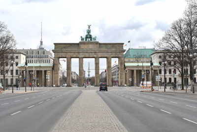 View of city street against cloudy sky