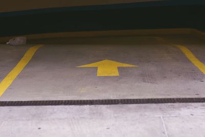 High angle view of arrow sign on parking lot