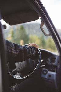 Cropped hand of person driving car