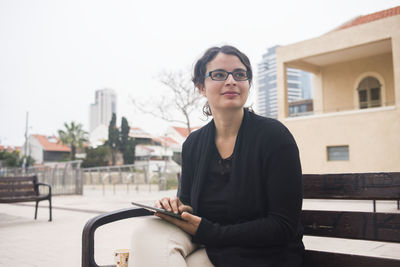 Young woman sitting in city