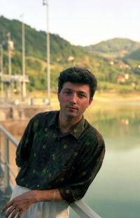 Portrait of man leaning on railing