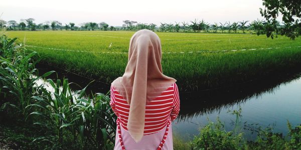 Rear view of woman standing on field