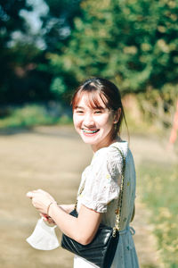 Portrait of young woman standing on field