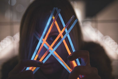 Woman holding colorful equipment at night