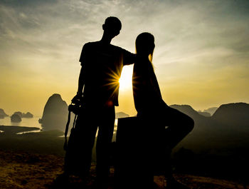 Silhouette couple against sky during sunset