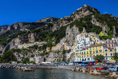 View of the city of amalfi from the jetty with parked buses, the sea and the colorful houses 