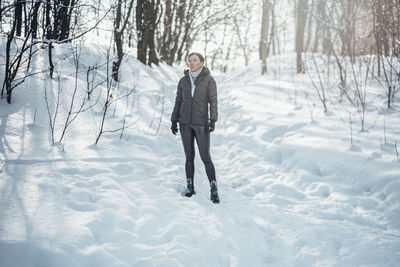 Full length of woman standing on snow covered land