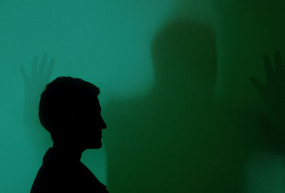 Portrait of silhouette woman against wall